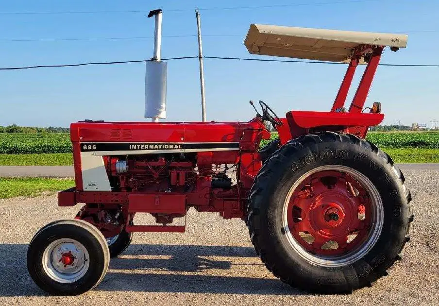 A red tractor parked on a dirt road.